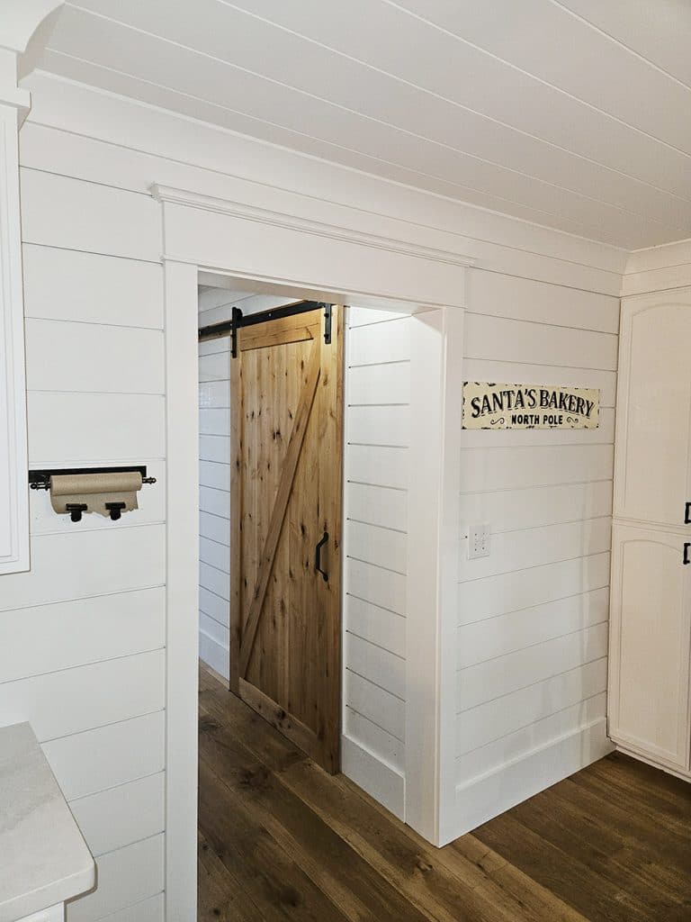 Farmhouse style shiplap walls, wide plank flooring, Craftsman trim and sliding bard door.