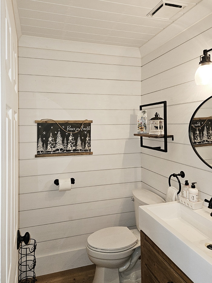 Powder room with shiplap walls, black hardware and stain grade cabinet