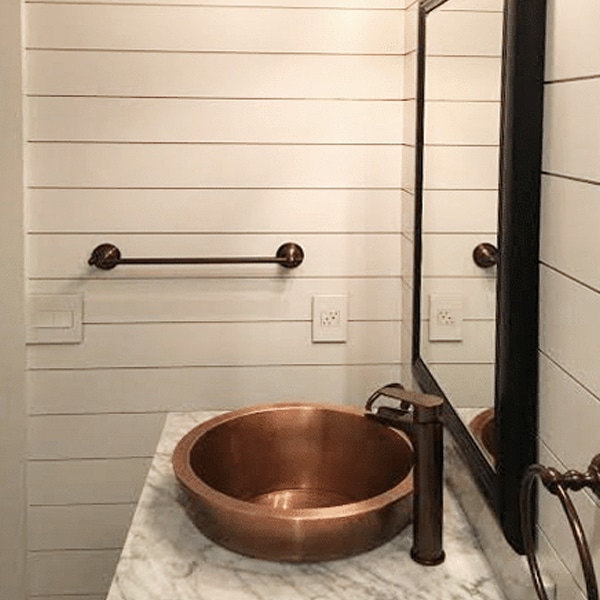 Shiplap in the powder room with black bronze hardware and copper sink