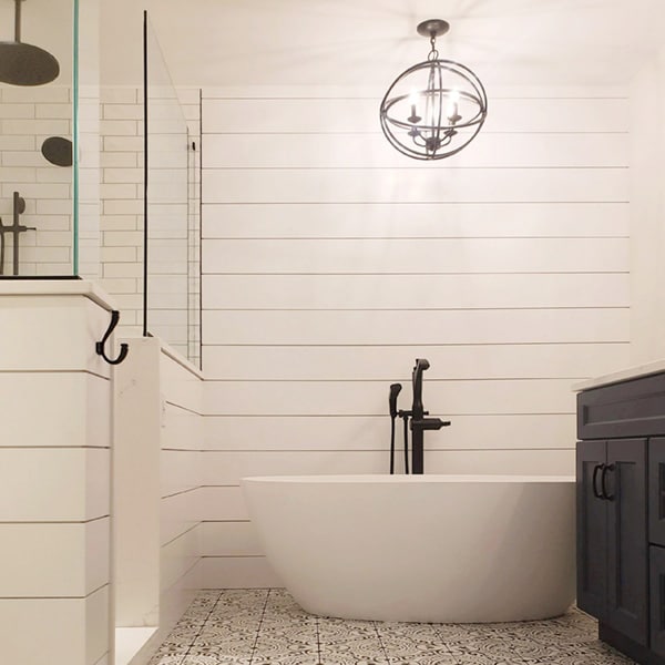 Shiplap bathroom with minimalist streamline tub and circular chandelier above