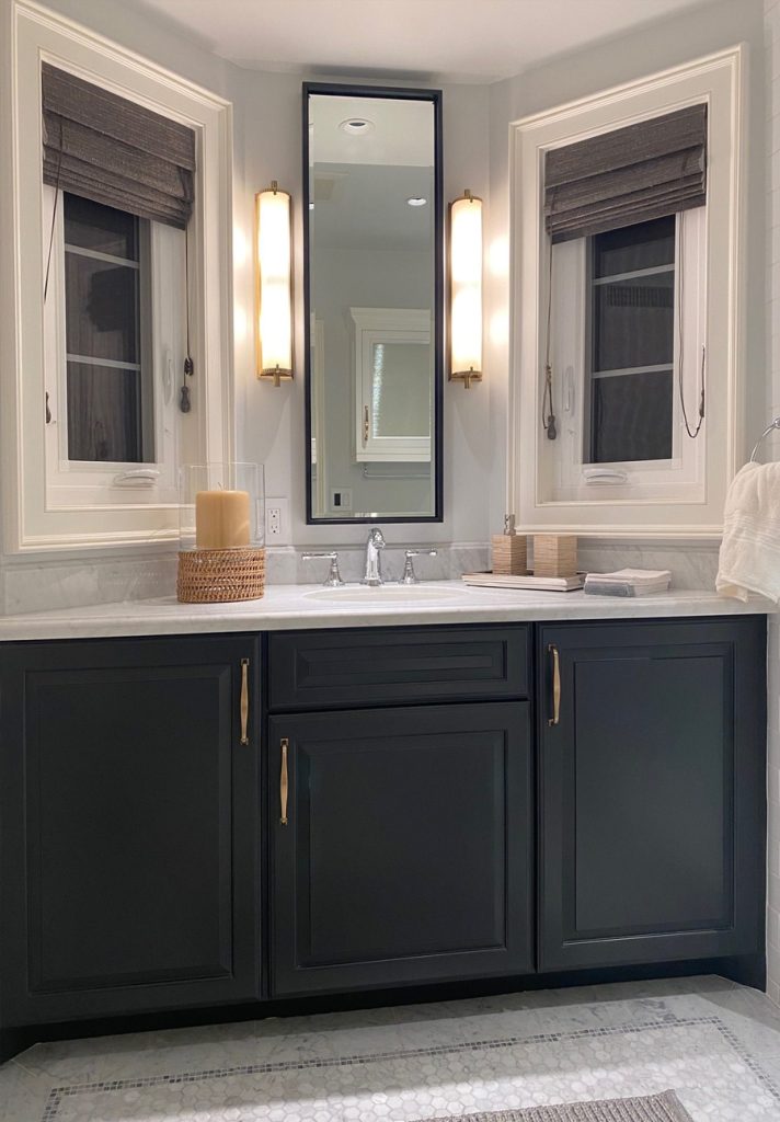 Bathroom with navy cabinets and 2 windows flanking mirror, trimmed out in beaded casing and federal panel mold