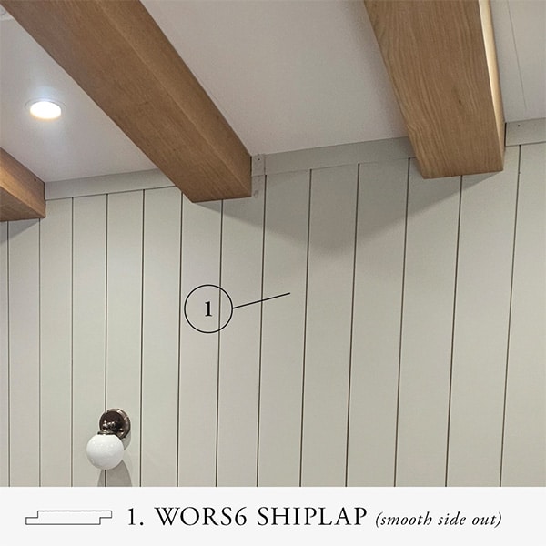 Shiplap wall painted light gray with natural ceiling beams above.