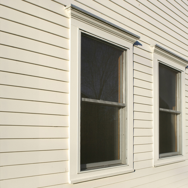 2 exterior windows trimmed with WindsorONE Protected boards, cream colored trim and siding