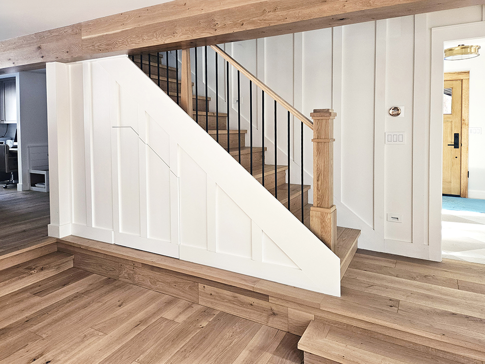 Farmhouse stair case, stain grade floor and steps, board and batten white WindsorONE boards on walls