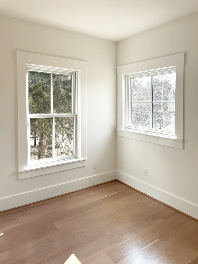 Corner of room with 2 windows with craftsman farmhouse molding
