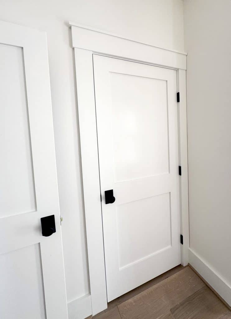 Door in corner, simple shaker 2 panel, molding around it is craftsman trim