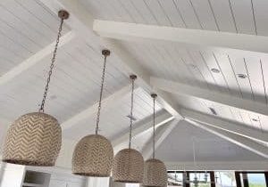 Shiplap vaulted ceiling with beams and hanging lamps